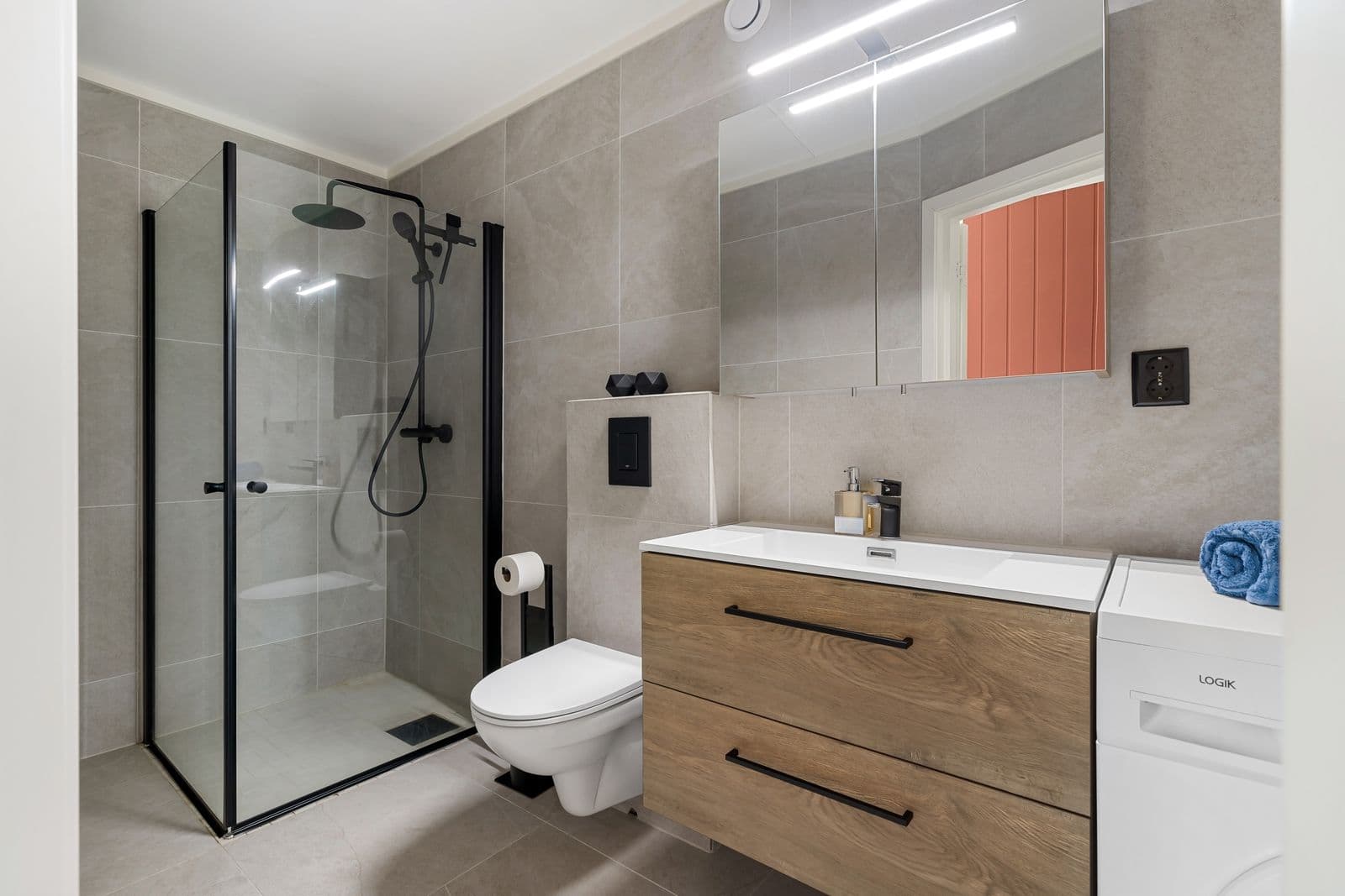 Saniertes Bad mit Holz-Waschtisch, schwarzen Armaturen und ebenerdiger Dusche