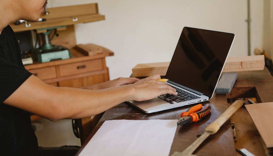 Handwerker kalkuliert Website-Kosten am Laptop