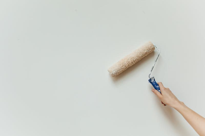 Malerarbeiten mit Farbrolle an weißer Wand